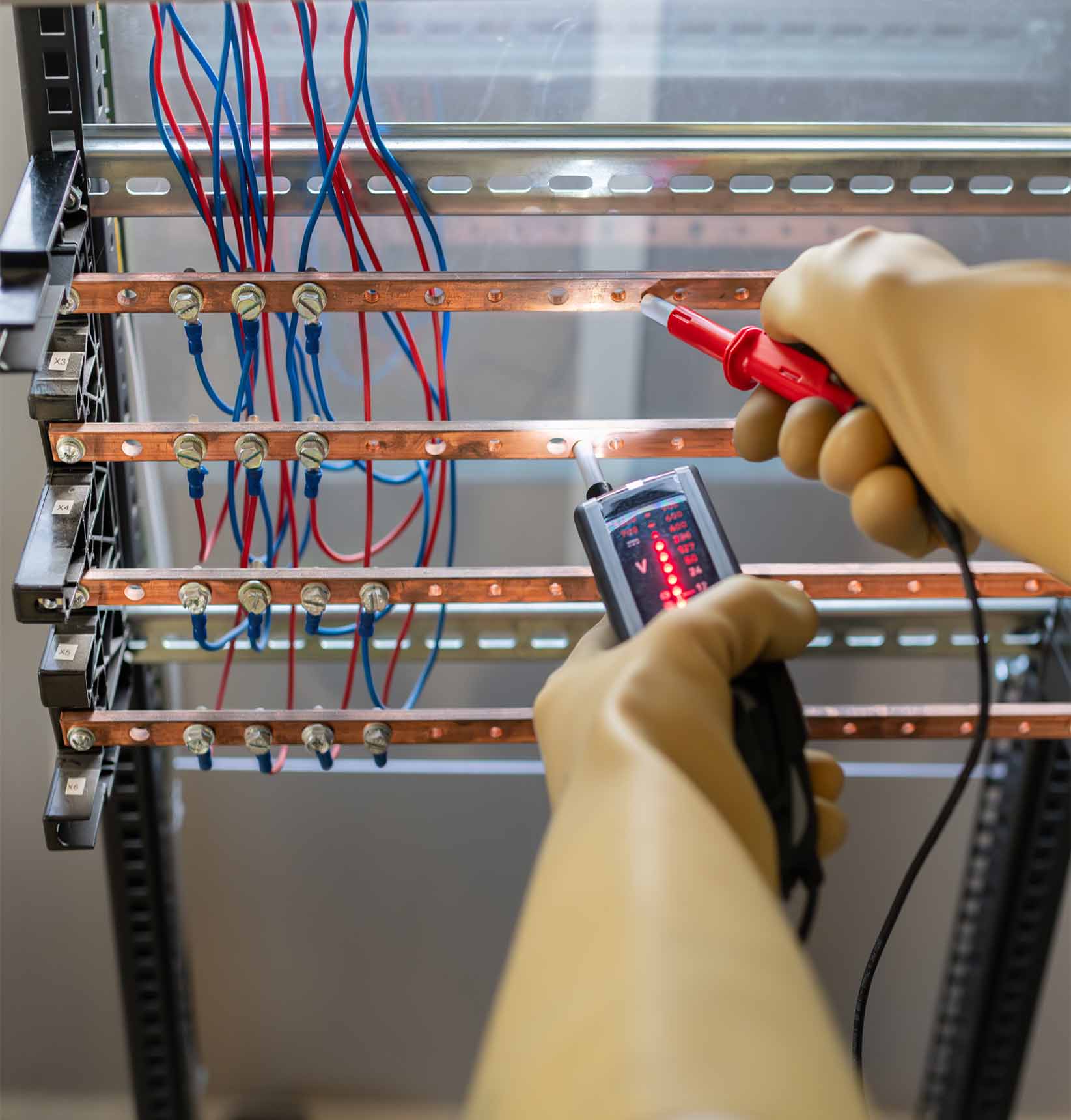 Vérification d’absence de tension (BC) avec un testeur bipolaire sur des barres de cuivre dans un tableau électrique, réalisée avec des gants isolants - Habilitation électrique BT