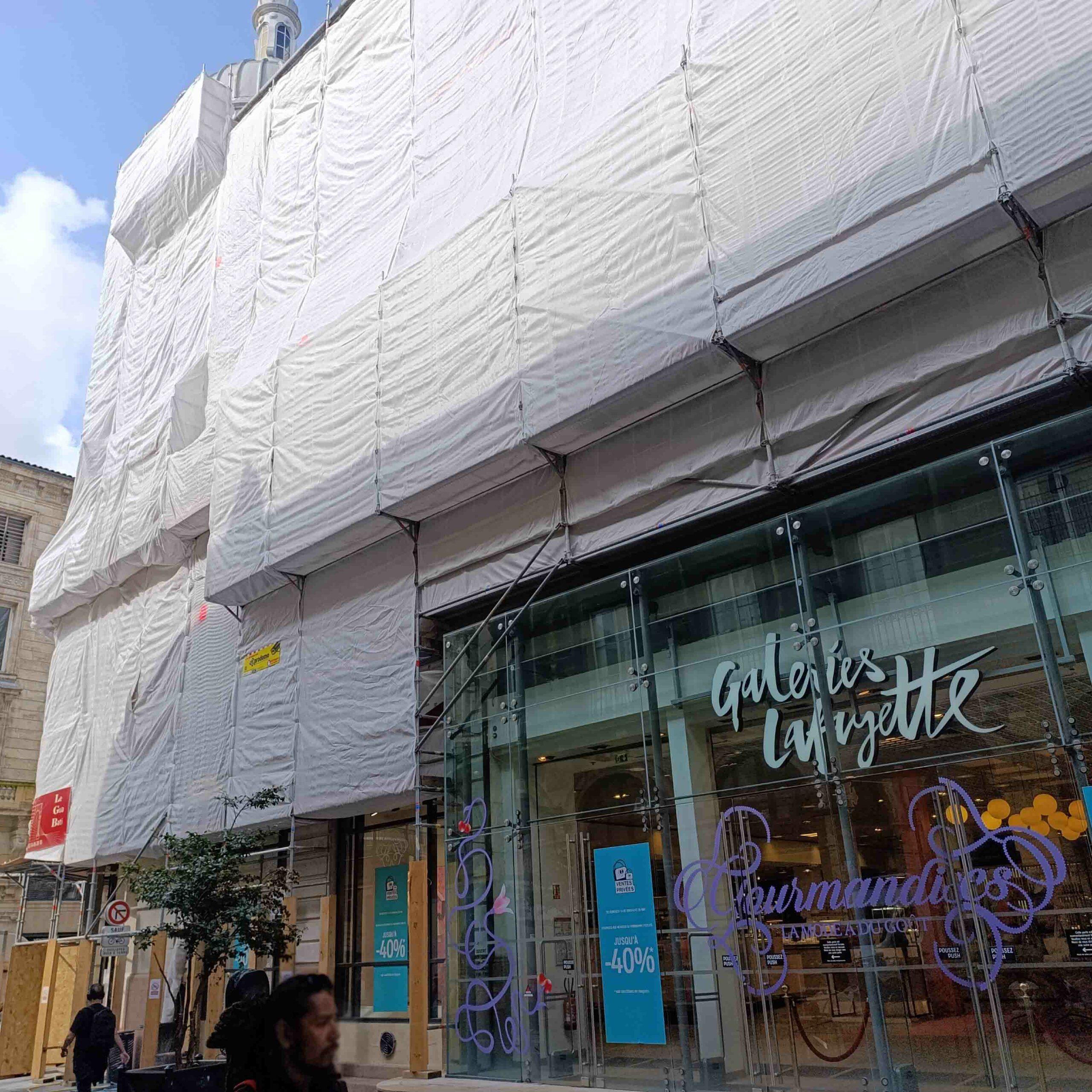 Travaux de façade aux Galeries Lafayette Bordeaux avec échafaudage bâché installé par les stagiaires formés chez Le Gua Bati