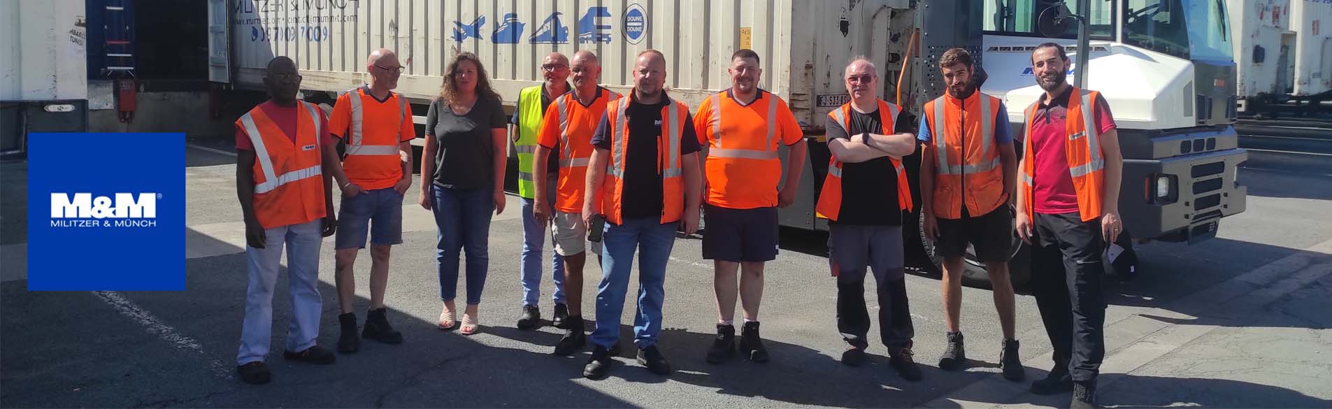 Groupe de salariés de M&M en gilets haute visibilité devant un entrepôt logistique M&M, suite à une formation risque chimique intra-entreprise.