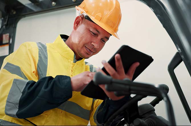 Opérateur contrôlant les données de maintenance sur une tablette.