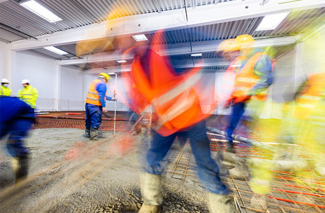 Ouvriers en équipement de protection travaillant sur un chantier en intérieur.