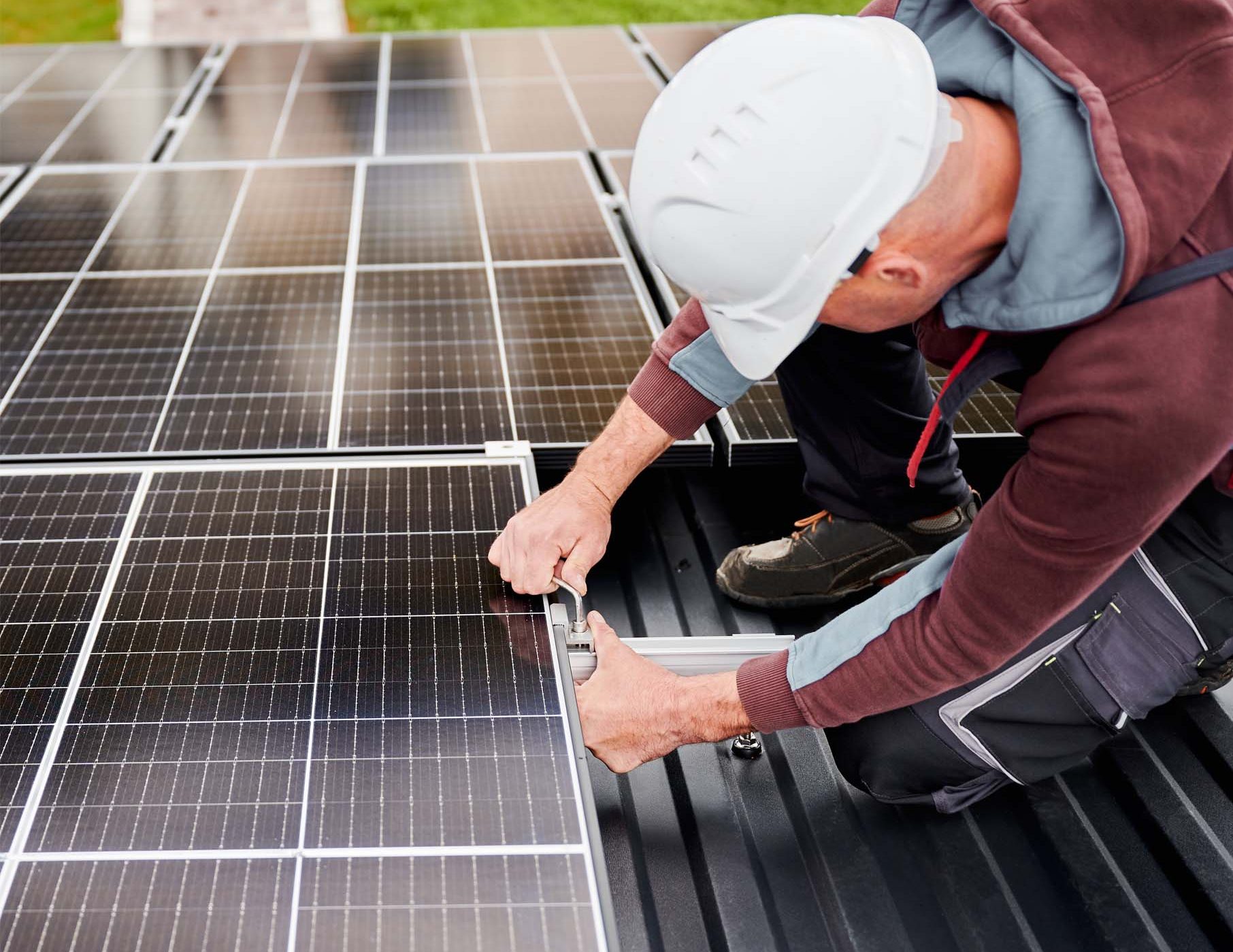 Technicien habilité BR-PV installant un panneau photovoltaïque sur une toiture.