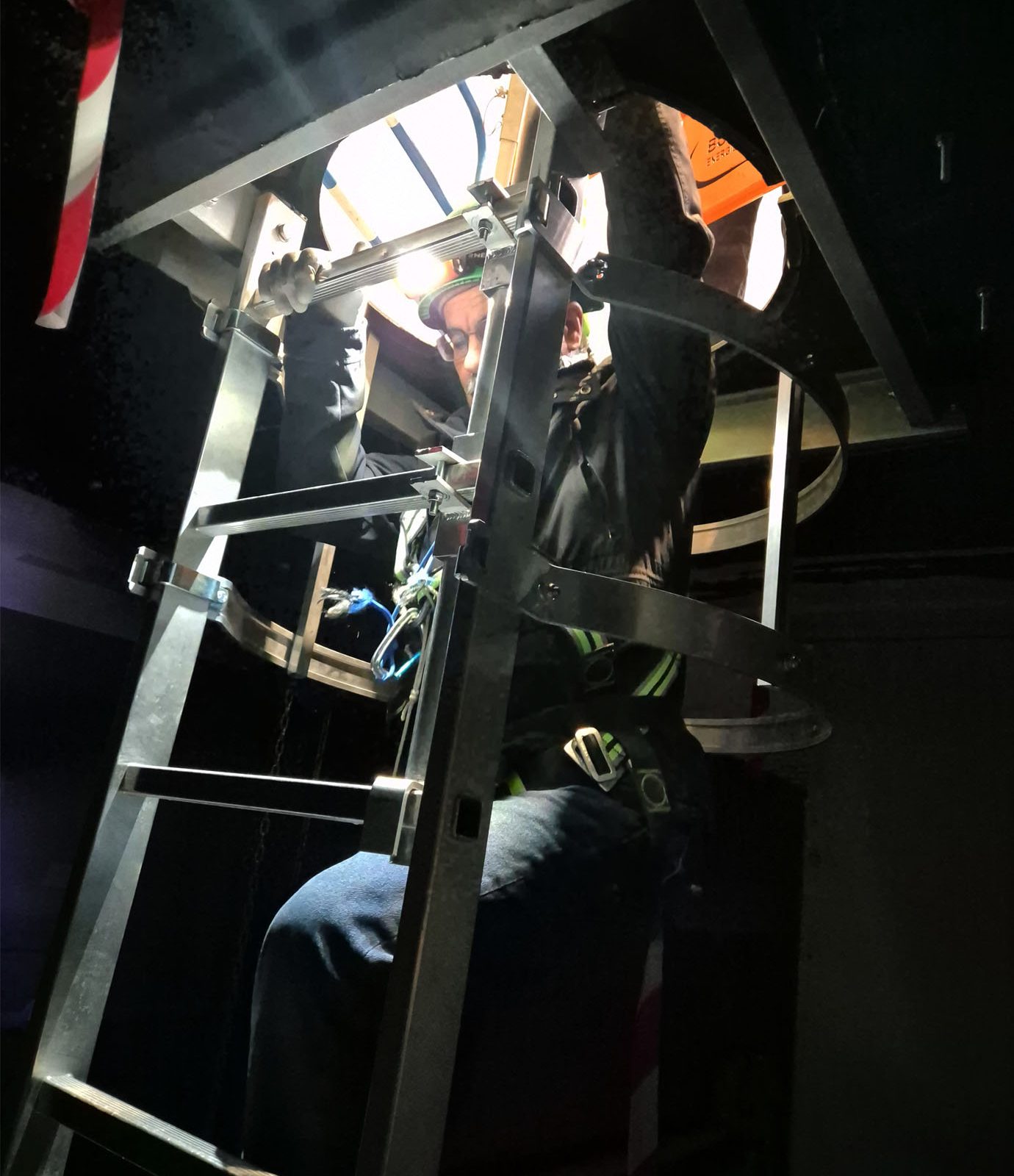 formation espace confiné : stagiaire descendant dans une bouche d’égout, entraînement pratique à la sécurité.